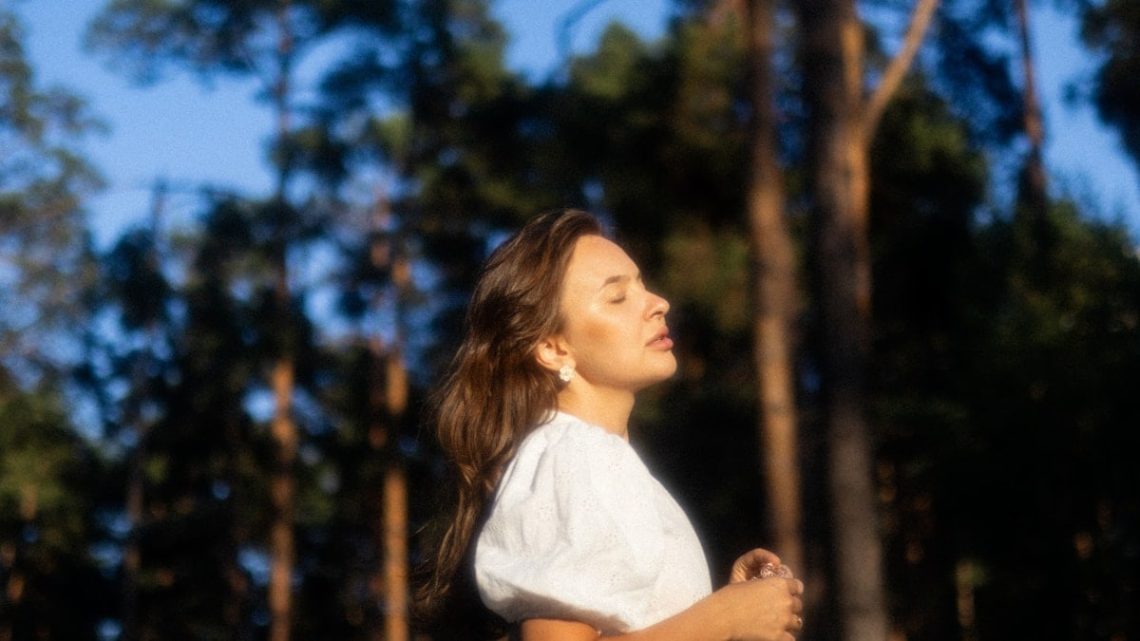 a woman in a white shirt is playing frisbee