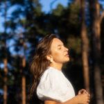 a woman in a white shirt is playing frisbee