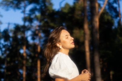a woman in a white shirt is playing frisbee